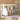 Close up of rectangular metal home name sign, with pine trees, in raw steel.