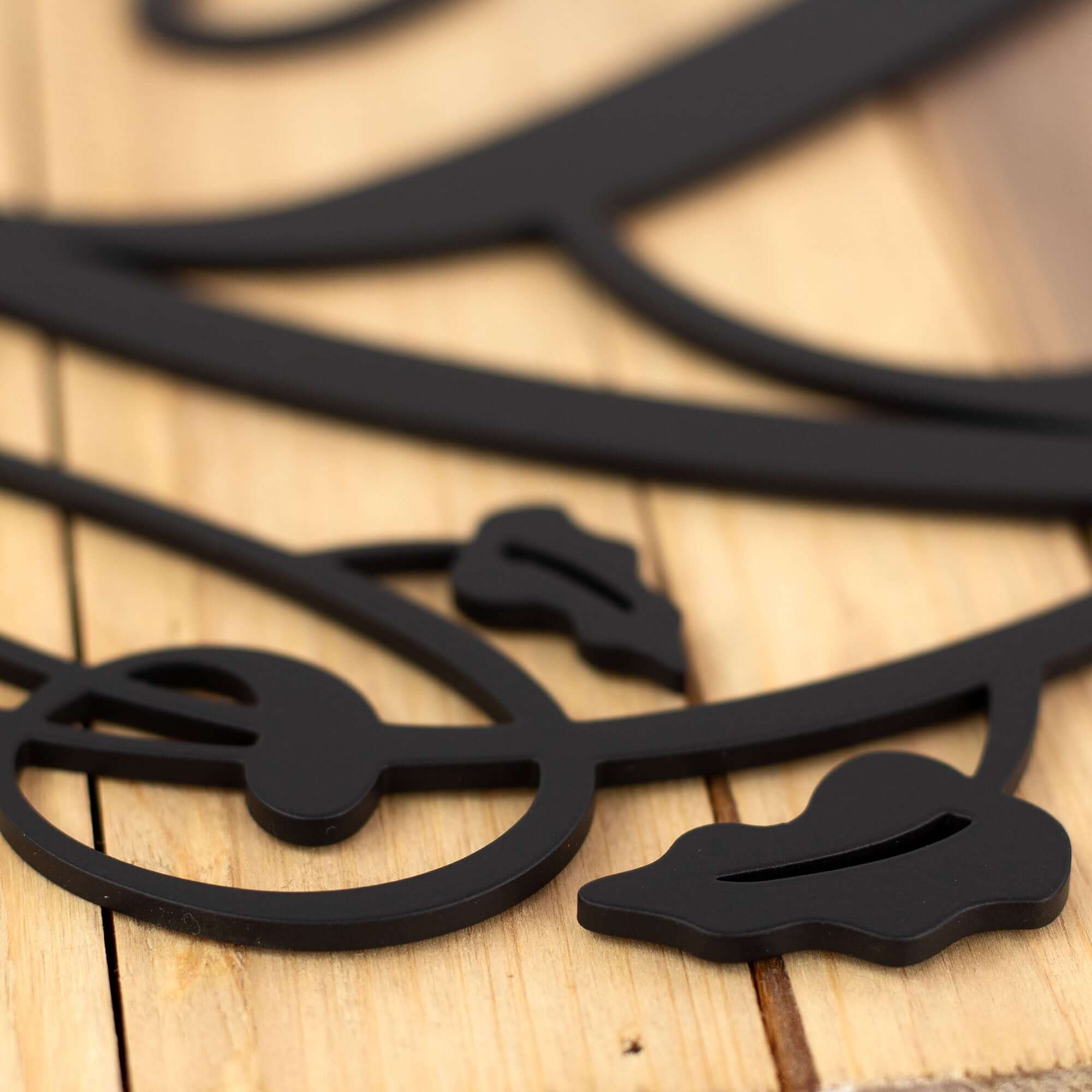 Close up of matte black powder coat on our monogram metal sign with vines.