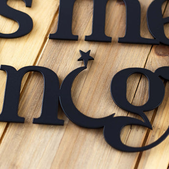 Close up of lettering on our Always Kiss Me Goodnight metal wall decor, in matte black powder coat. 
