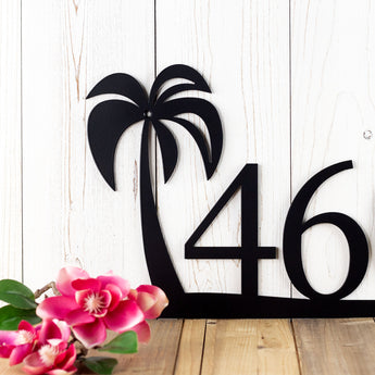 Close up of tropical palm tree on our metal house number sign, in matte black powder coat.