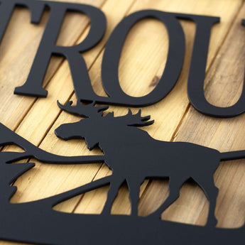 Close up of matte black powder coat on our metal family name sign with moose and mountains.