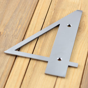 Close up of raw steel on modern metal house number sign.