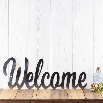 Welcome metal sign with script lettering, in raw steel. 