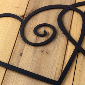 Close up of matte black powder coat on our curly hearts metal sign.