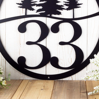 Close up of pine trees on our 2 digit metal address sign, in matte black powder coat.