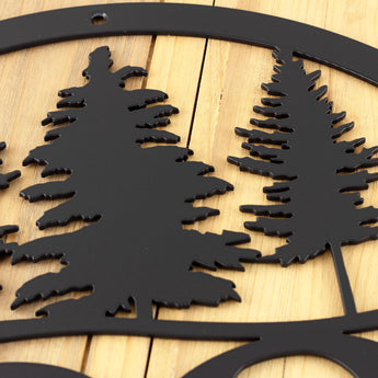 Close up of matte black powder coat on our metal house number sign with pine trees.