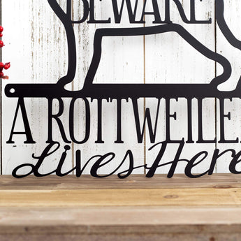 Close up of A Rottweiler Lives Here wording on our Rottweiler metal sign, in matte black powder coat.