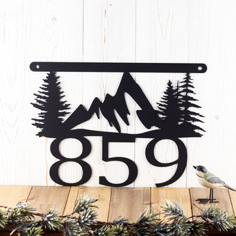 3 digit hanging metal house number plaque with mountains and pine trees, in matte black powder coat.