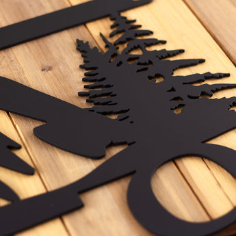 Close up of matte black powder coat on our 3 digit hanging metal house number sign with mountains and pine trees.