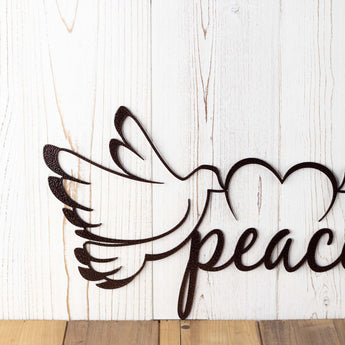 Close up of peace dove metal wall art, with a heart, in copper vein powder coat.