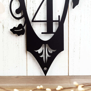 Close up of fleur de lis and mounting hole on our 3 digit vertical house number plaque, in matte black powder coat.