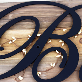Close up of script letter on our family name metal sign, in matte black powder coat. 