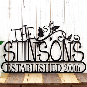 Personalized family name and established year metal sign with vines, in matte black powder coat. 