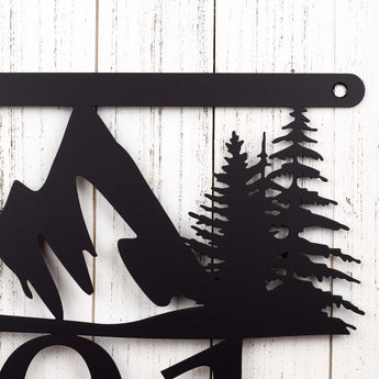 Close up of mountains and pine trees on our hanging metal house number sign, in matte black powder coat.