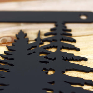 Close up of matte black powder coat on our metal house number sign with pine trees. 