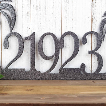 Close up of house number on our palm tree metal house number sign, in silver vein powder coat.