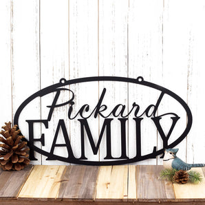 Personalized oval family name sign with a script font, in matte black powder coat. 