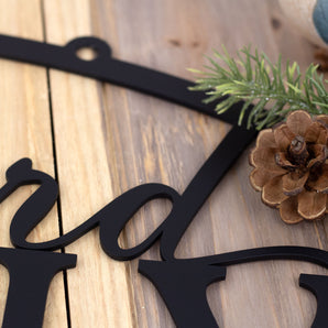 Close up of matte black powder coat on the oval family name sign. 