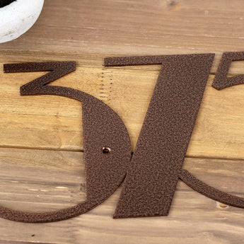 Close up of copper vein powder coat on modern metal house number sign.