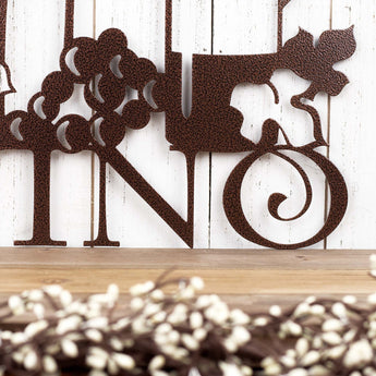 Close up of Vino word on our Vino metal wall art with grapes, in copper vein powder coat. 