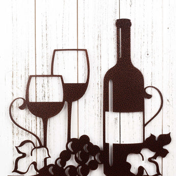 Close up of wine glasses, wine bottle, and grapes on our Vino metal wall art, in copper vein powder coat. 