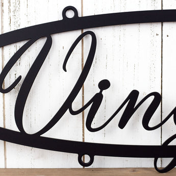 Close up of family name on our hanging oval metal sign, in matte black powder coat.
