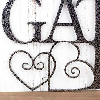 Close up of hearts on our Family & Friends Gather Here metal wall art, in silver vein powder coat. 