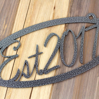 Close up of silver vein powder coat on our oval established year metal plaque. 