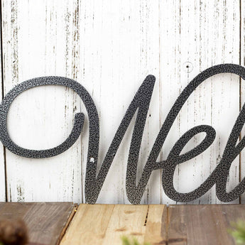 Close up of welcome script metal wall decor, in silver vein powder coat.