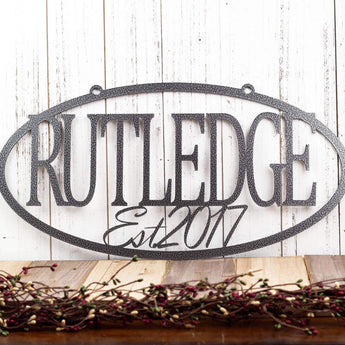 Hanging oval custom family name and established year metal sign, in silver vein powder coat. 