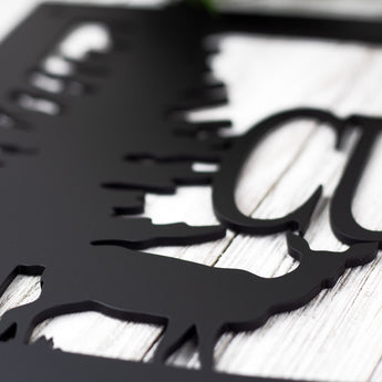 Close up of matte black powder coat on our custom family name metal sign with doe deer silhouette.