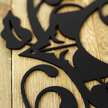 Close up of matte black powder coat on our 4 digit metal house number sign with fleur de lis and vines.
