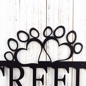 Close up of dog paws on our custom metal sign, in matte black powder coat. 