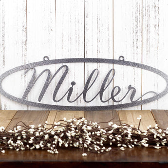 Oval family last name metal sign with script font, in silver vein powder coat.