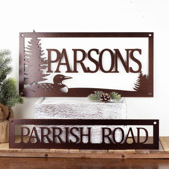 Hanging rectangular family name and address plaques, with a loon and lake scene, in copper vein powder coat. 