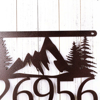 Close up of mountains and pine trees on our 5 digit hanging metal house number sign. 