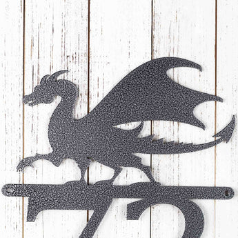 Close up of a dragon silhouette on the 2 digit metal house number sign, in silver vein powder coat. 