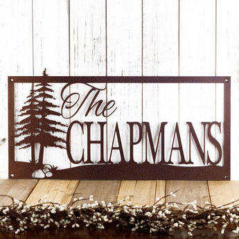 Rectangular metal family name sign with pine trees, in copper vein powder coat. 