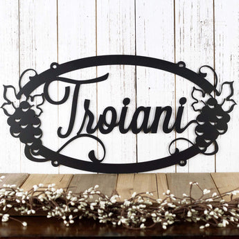 Oval personalized name metal plaque with grapevines, in script lettering. 