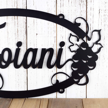Close up of grapes and grapevines on our oval custom metal plaque, in matte black powder coat. 