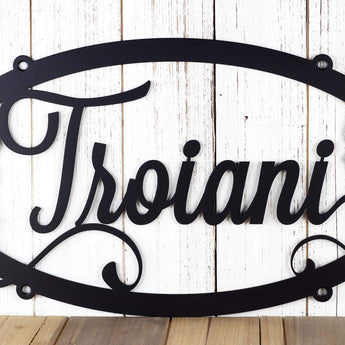 Close up of family last name on our grapevines oval metal sign, in matte black powder coat.