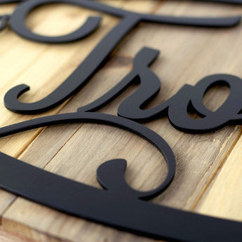 Close up of matte black powder coat on our grapevines custom name oval metal plaque. 