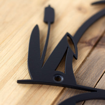 Close up of matte black powder coat on our heron & cattails custom metal sign. 
