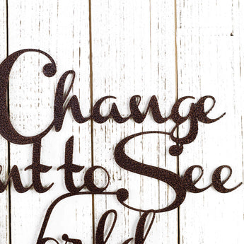 Close up of Be the Change you Want to See in the World metal sign, in copper vein powder coat.
