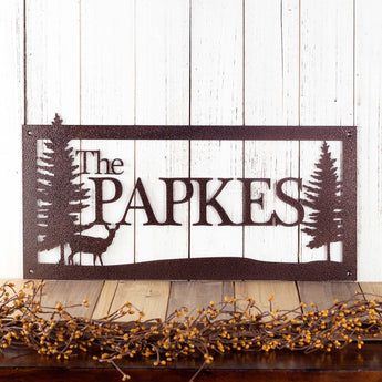 Rectangular family name metal sign with a doe deer and pine trees, in copper vein powder coat