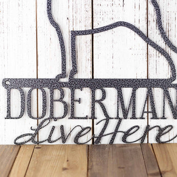 Close up of wording on our Dobermans Live Here metal sign, in silver vein powder coat.