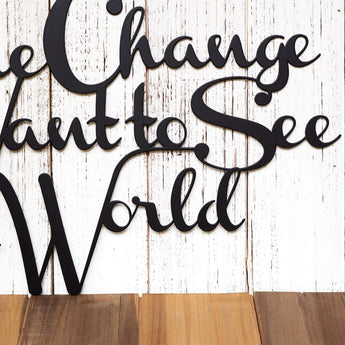 Close up of Be the Change you Want to See in the World metal sign, in matte black powder coat.