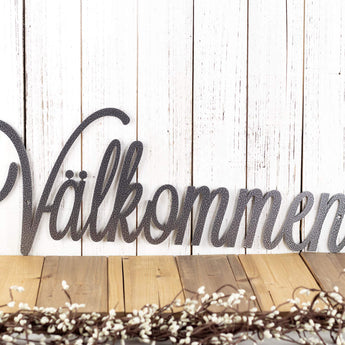Close up of script lettering on our Välkommen metal wall art, in silver vein powder coat.