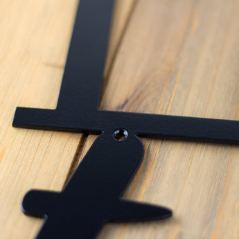 Close up of mounting hole on our Love is Rare Treasure It metal wall decor, in matte black powder coat. 