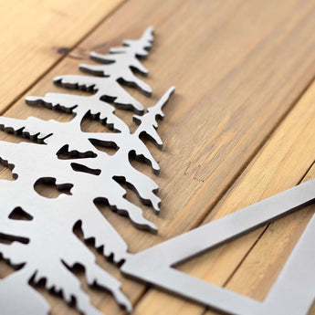 Close up of raw steel on our 2 digit metal house number sign with pine trees.